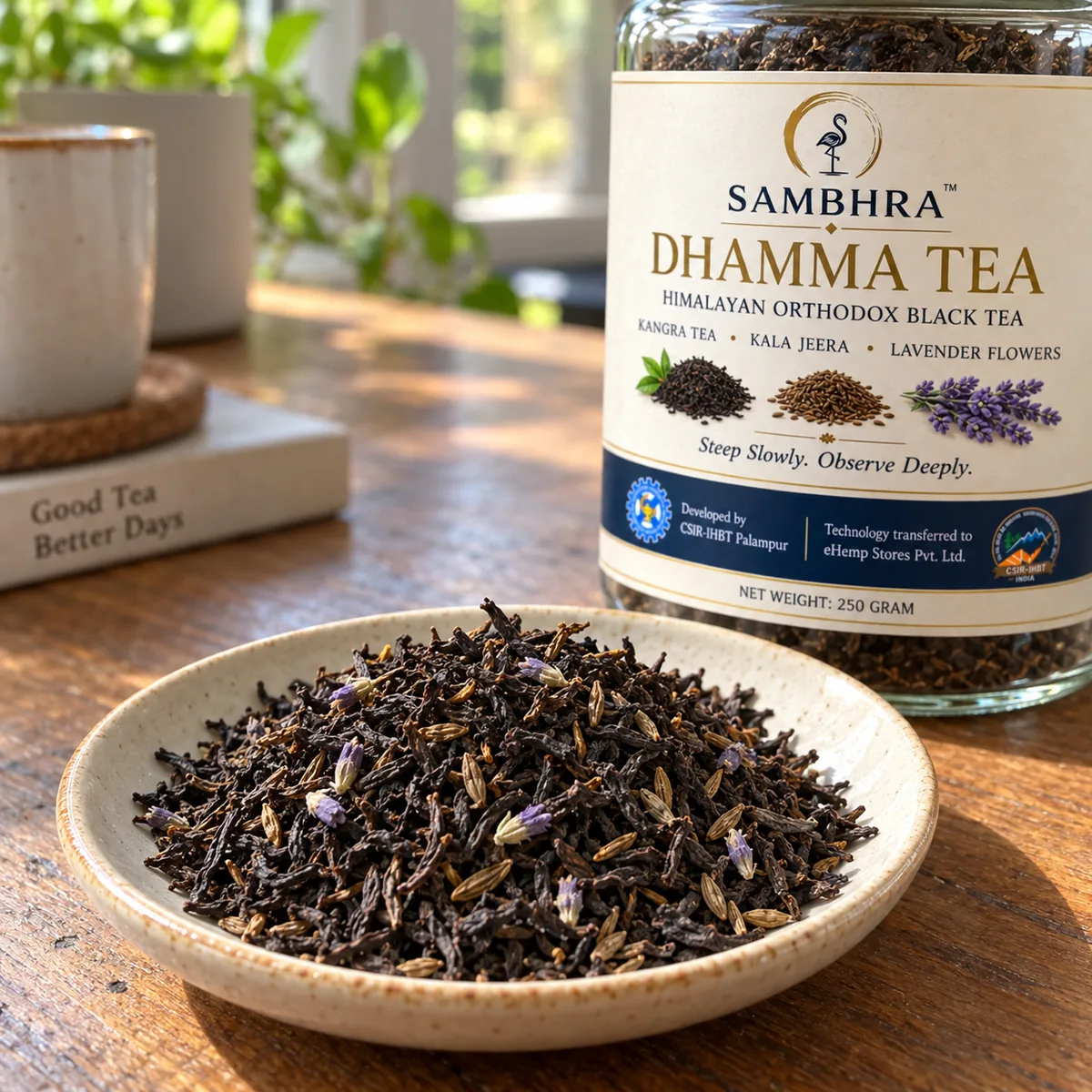 Dhamma Tea loose leaf on a saucer Dry Dhamma Tea on a cream saucer: twisted dark orthodox black tea leaves with a few lavender flowers and slender kala jeera seeds
