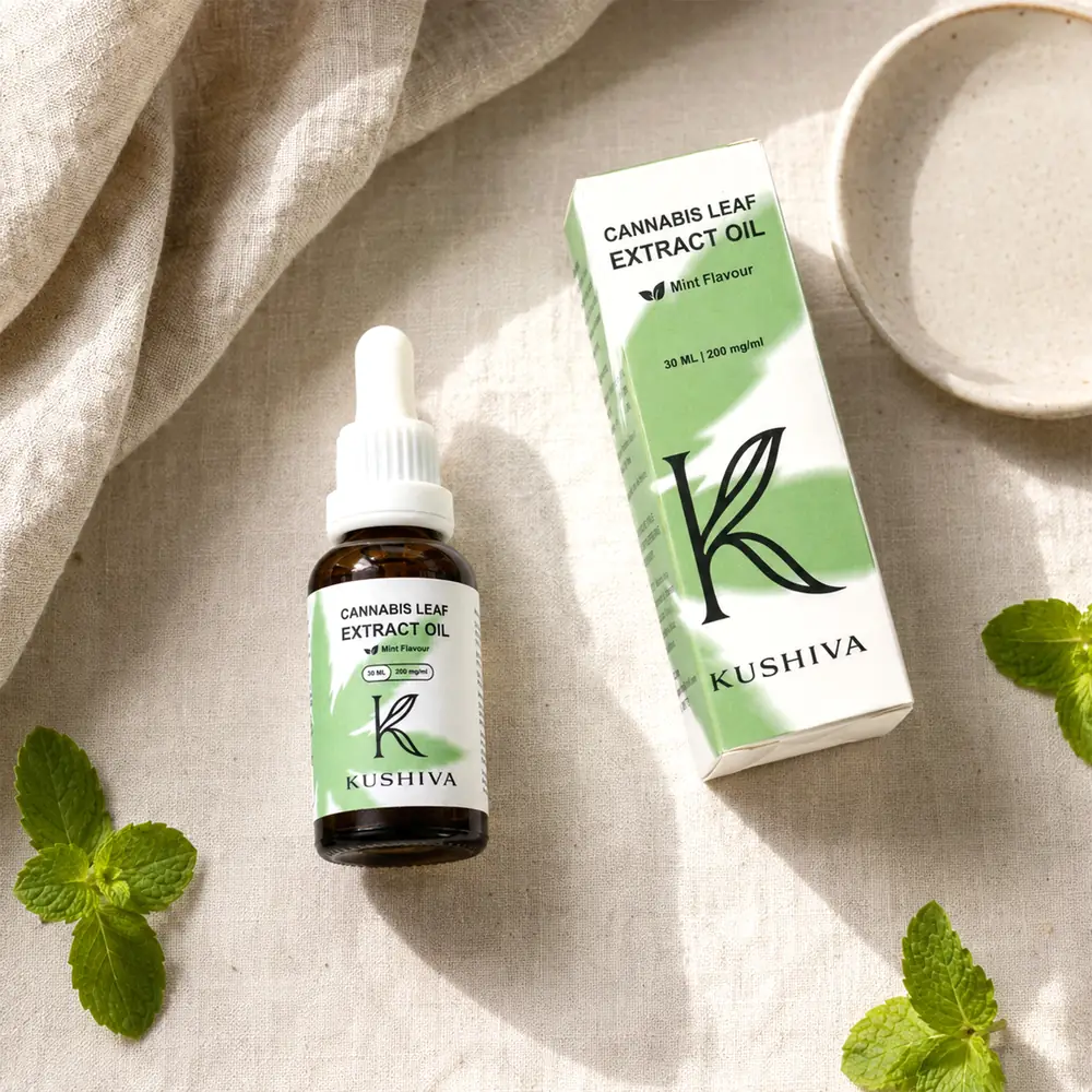 Kushiva Cannabis Leaf Extract Oil 30 ml bottle beside its mint-flavour carton, flat lay with fresh mint
